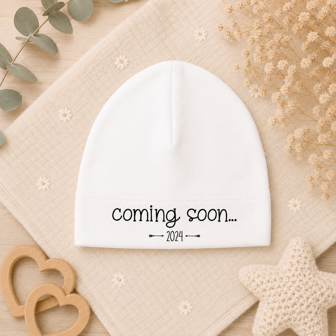Wit babymutsje met tekst “coming soon…” van organic katoen, ideaal voor zwangerschapsaankondiging en cadeau