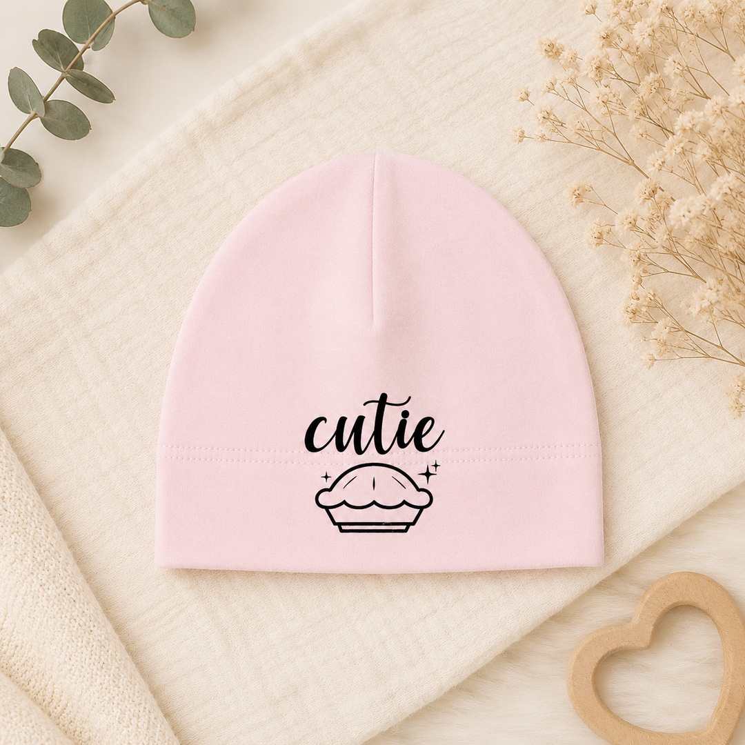 Roze babymutsje met tekst “cutie” en cupcake, newborn mutsje van organic katoen