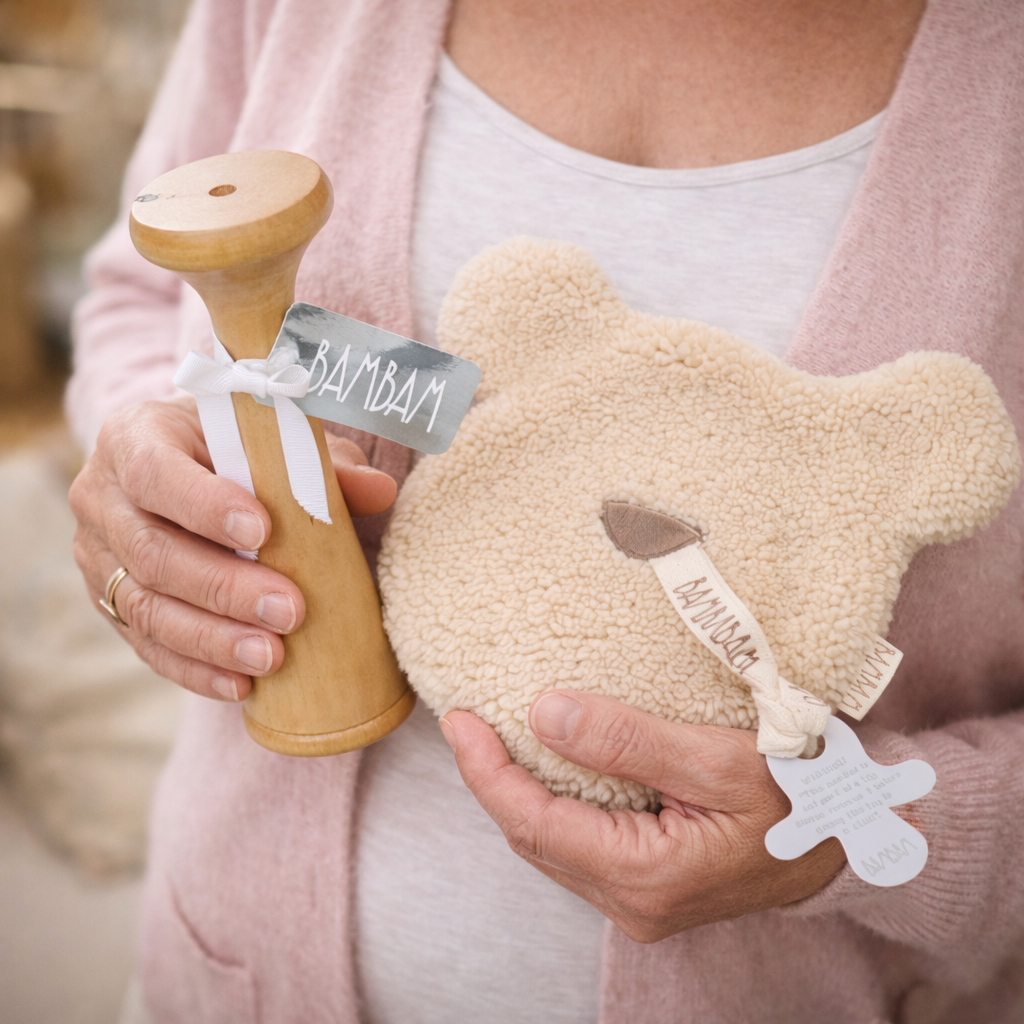 Handen van vrouw houden BamBam Doptone en teddy speendoekje vast – perfect cadeau voor zwangerschap of babyshower.