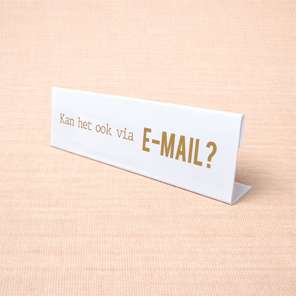Wit bureau naamplaatje met tekst “Kan het ook via E-mail?” op een bureau