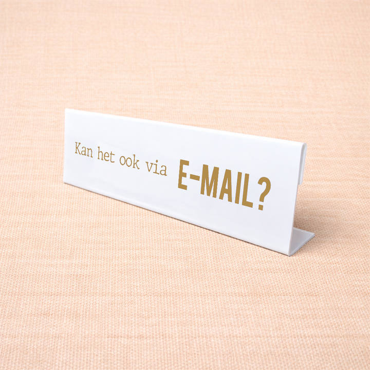 Wit bureau naamplaatje met tekst “Kan het ook via E-mail?” op een bureau
