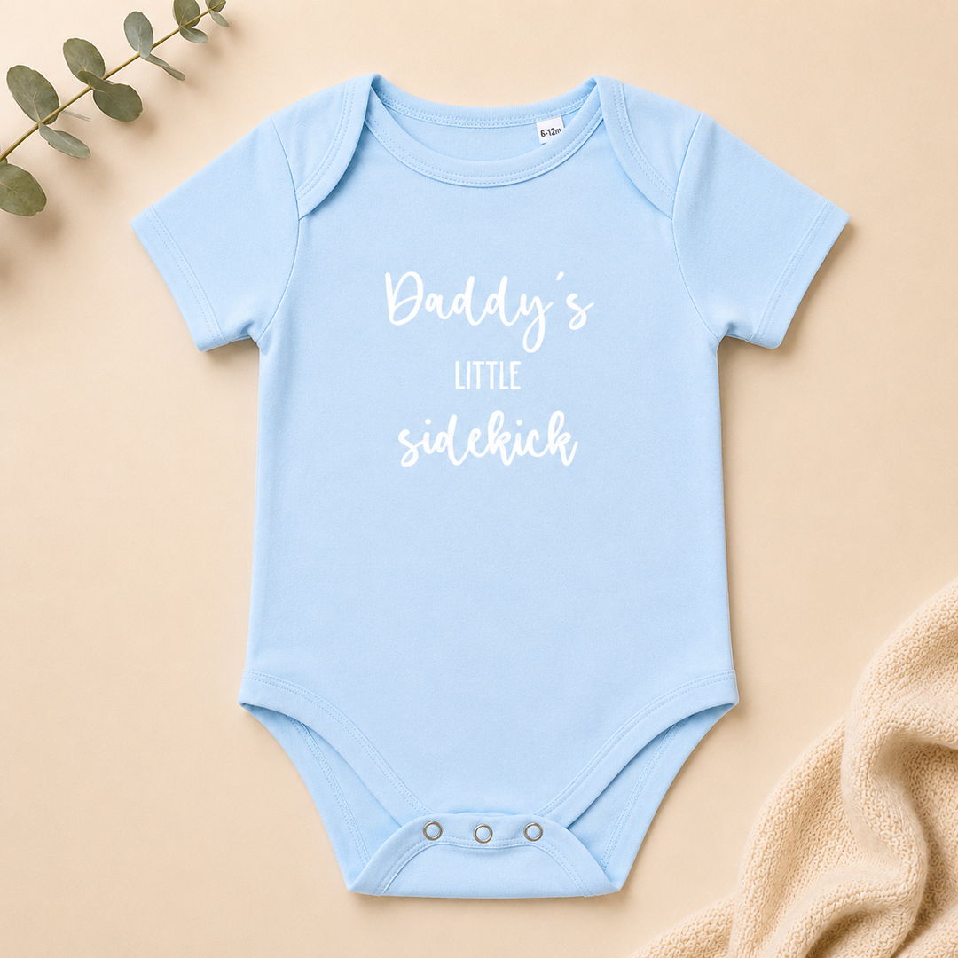 Baby rompertje “Daddy’s little sidekick” in baby blauw, organic katoenen rompertje met tekst voor zwangerschapsaankondiging en kraamcadeau
