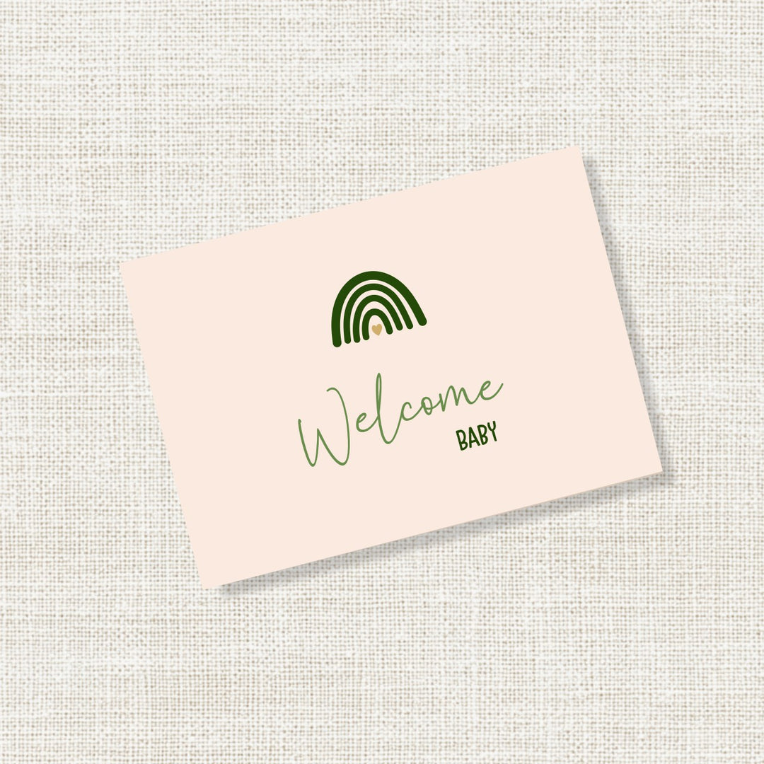 Zand felicitatiekaartje met groene regenboog en de tekst Welcome baby