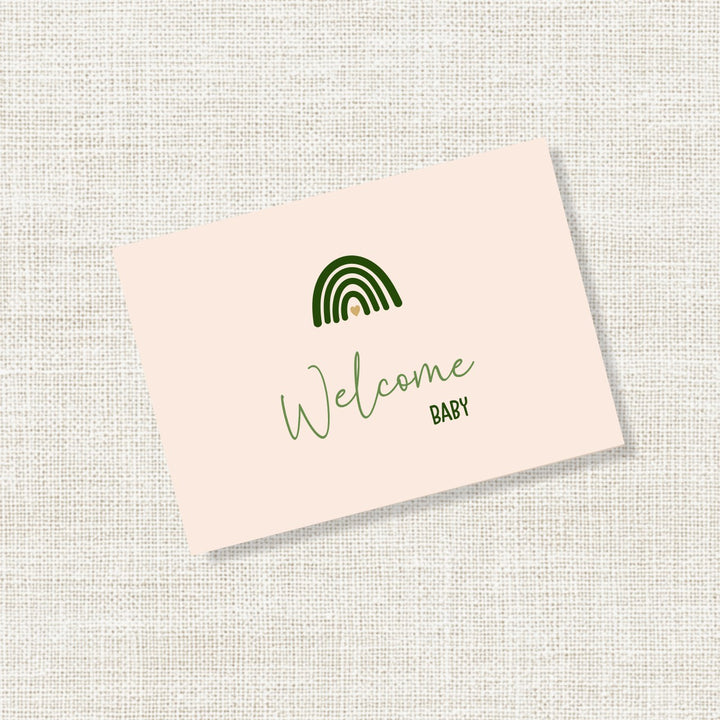 Zand felicitatiekaartje met groene regenboog en de tekst Welcome baby