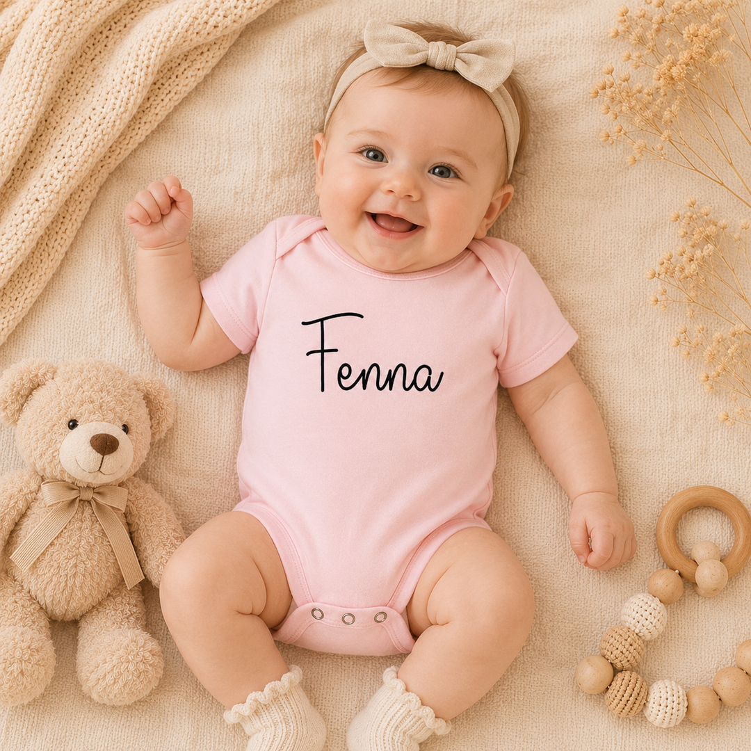 Baby draagt gepersonaliseerd rompertje met naam Fenna in baby roze, zacht organic katoenen rompertje met enveloppe schouder en drukknoopjes (kraamcadeau)