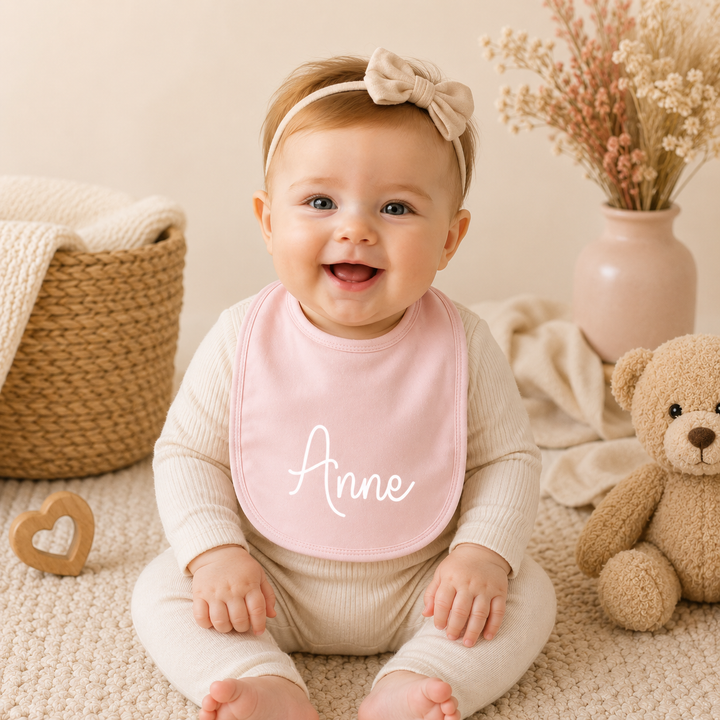 Baby draagt gepersonaliseerd slabbetje met naam, ideaal als kraamcadeau of babyshower cadeau