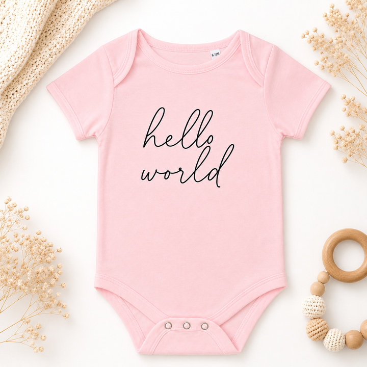 Roze babyrompertje met tekst “hello world”, organic katoen, geschikt als zwangerschapsaankondiging en babycadeau