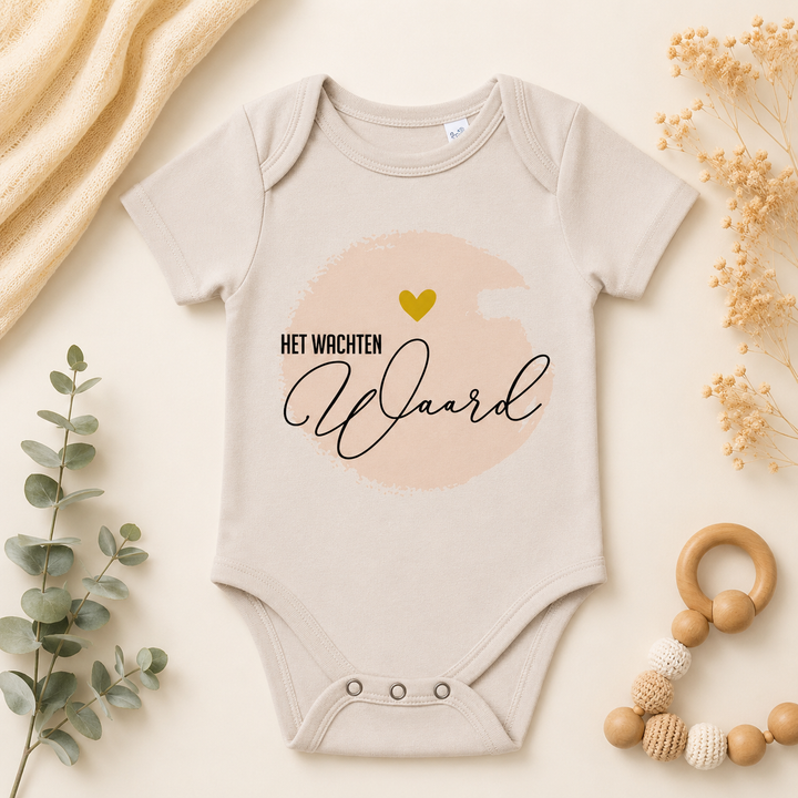 Beige IVF rompertje met tekst “Het wachten waard” voor zwangerschapsaankondiging IVF, ICSI, IUI of KID