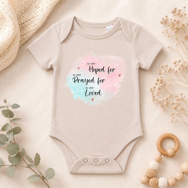 Beige IVF rompertje “So very hoped for” van biologisch katoen, zwangerschapsaankondiging bij kinderwens/IVF