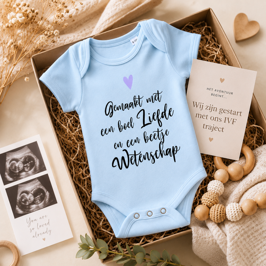 Babyblauw IVF rompertje in cadeaupakket met kaart en echo, tekst “Gemaakt met een boek liefde en een beetje wetenschap” – origineel IVF cadeau en zwangerschapsaankondiging