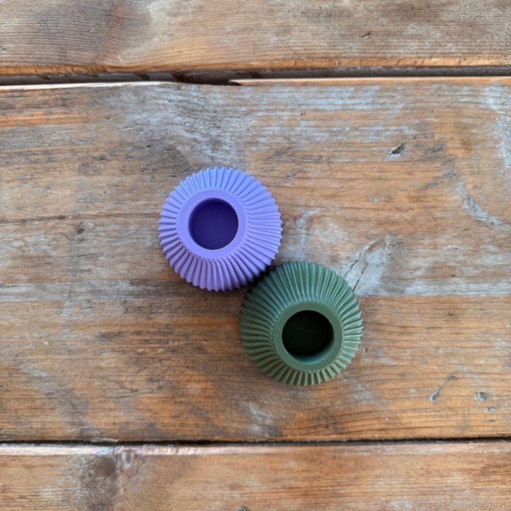 Twee 3D-geprinte kaarsenhouders Kees in verschillende kleuren op houten ondergrond