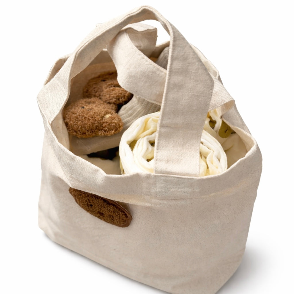 Naturel tasje met beertje gevuld met babyproducten als kraamcadeau