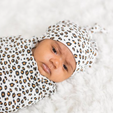 Baby ingepakt in Lulujo leopard swaddle doek met newborn mutsje van bamboo mousseline, zachte hydrofiele doek voor inbakeren