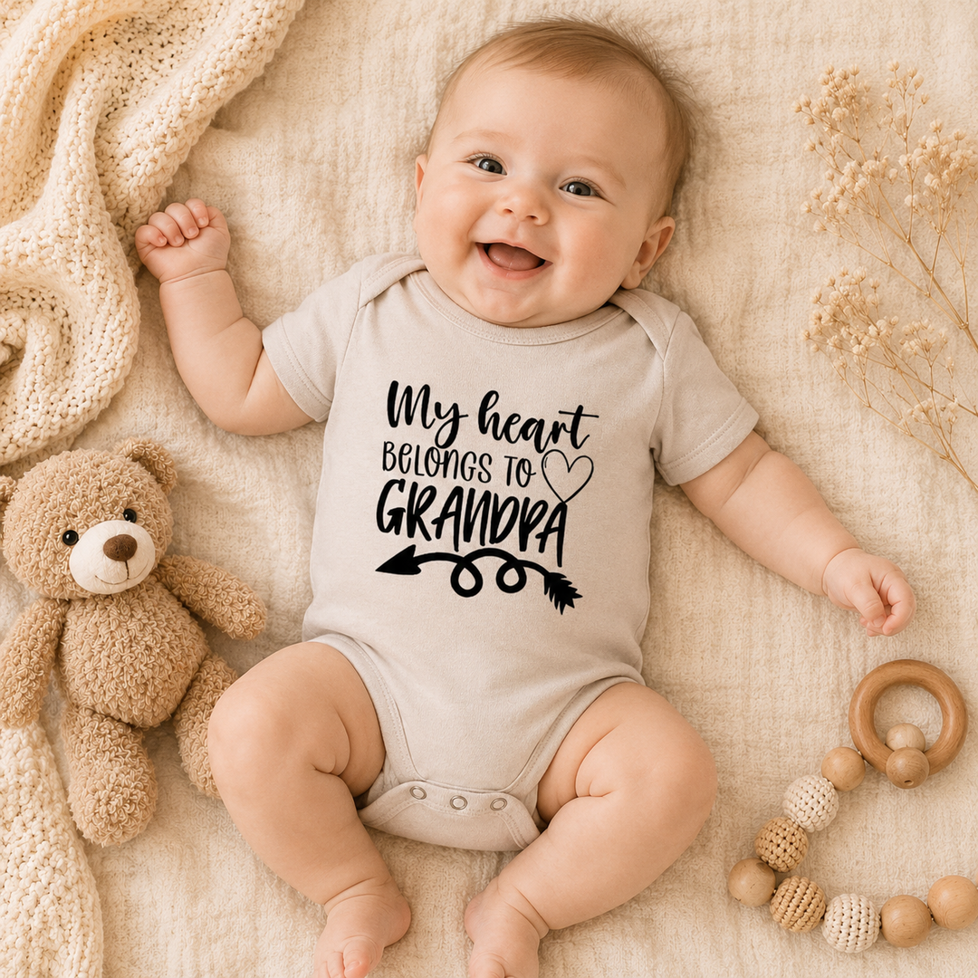 Baby draagt beige rompertje met tekst “My heart belongs to grandpa” – origineel cadeau voor opa en zwangerschapsaankondiging