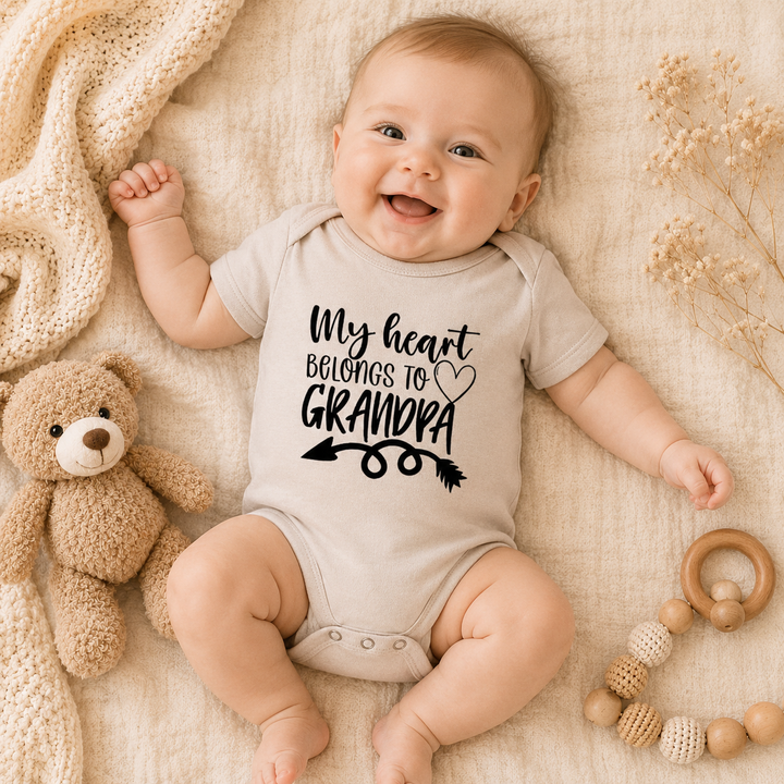 Baby draagt beige rompertje met tekst “My heart belongs to grandpa” – origineel cadeau voor opa en zwangerschapsaankondiging