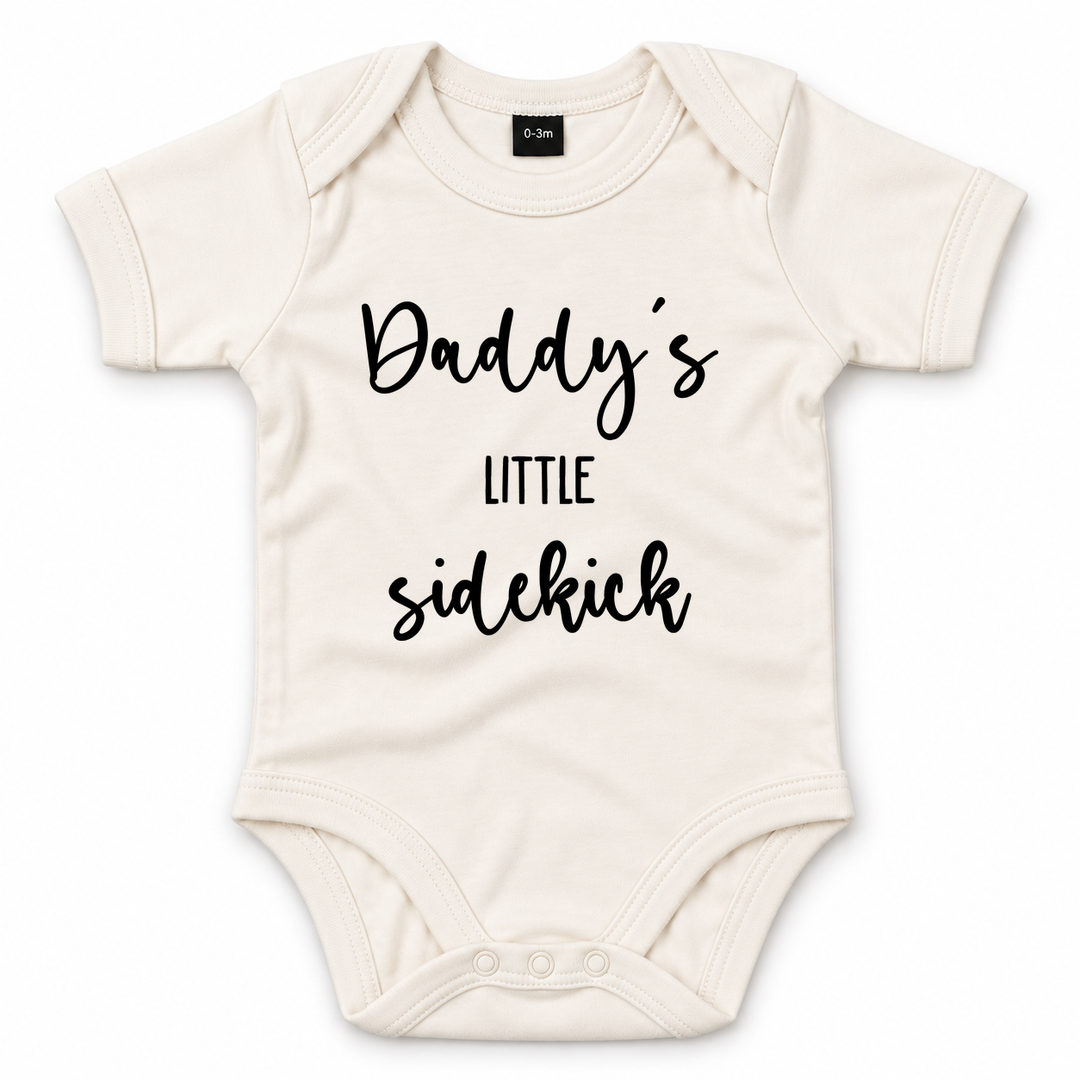 Naturelkleurige baby romper met zwarte tekst Daddy’s Little Sidekick.