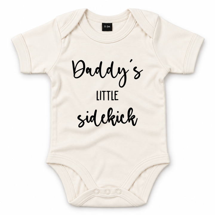 Naturelkleurige baby romper met zwarte tekst Daddy’s Little Sidekick.