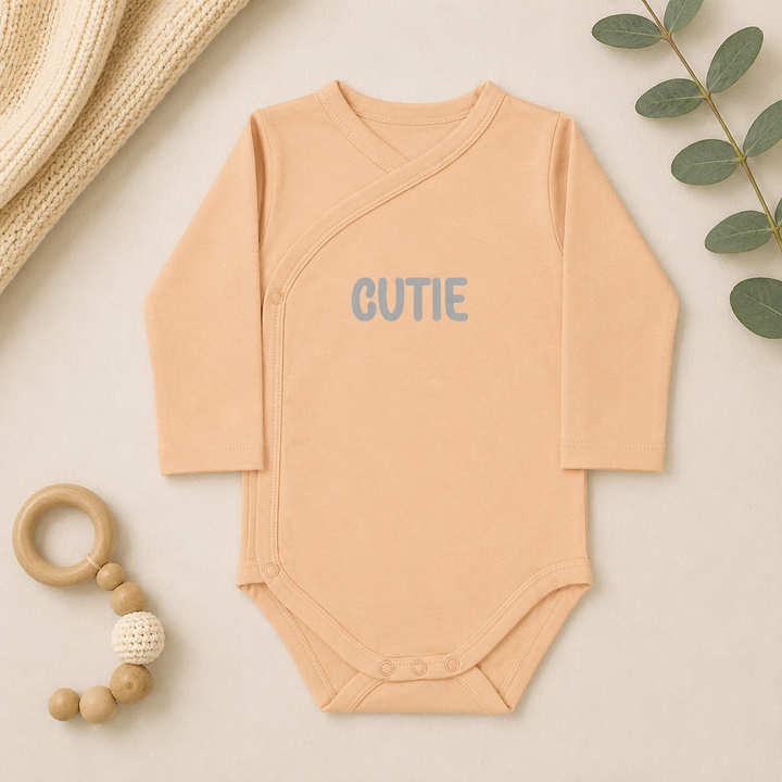 Perzikkleurige prematuur romper maat 44 met lange mouw en “Cutie” opdruk – kraamcadeau prematuur baby