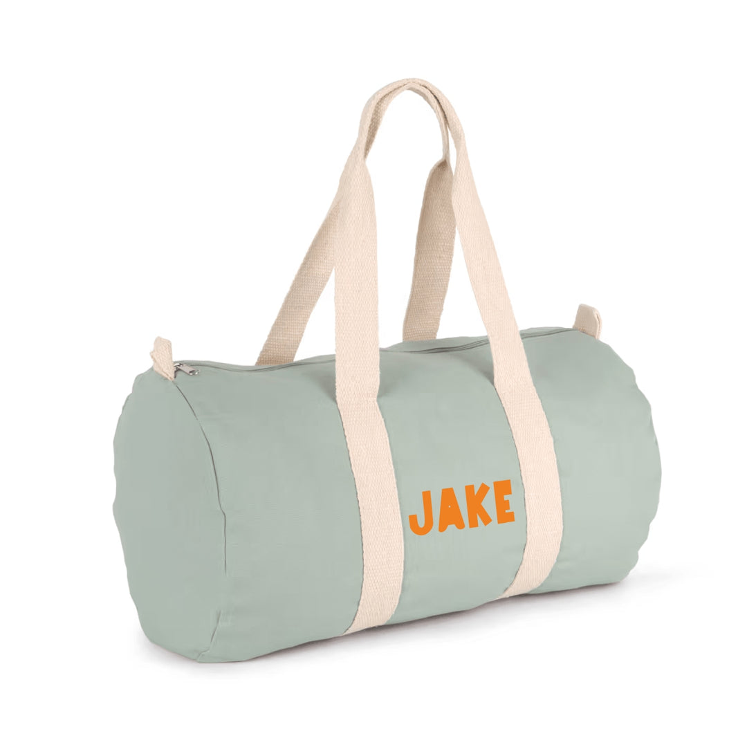 reistas met naam Jake in oranje bedrukking, gepersonaliseerde canvas weekendtas voor kinderen in saliegroen