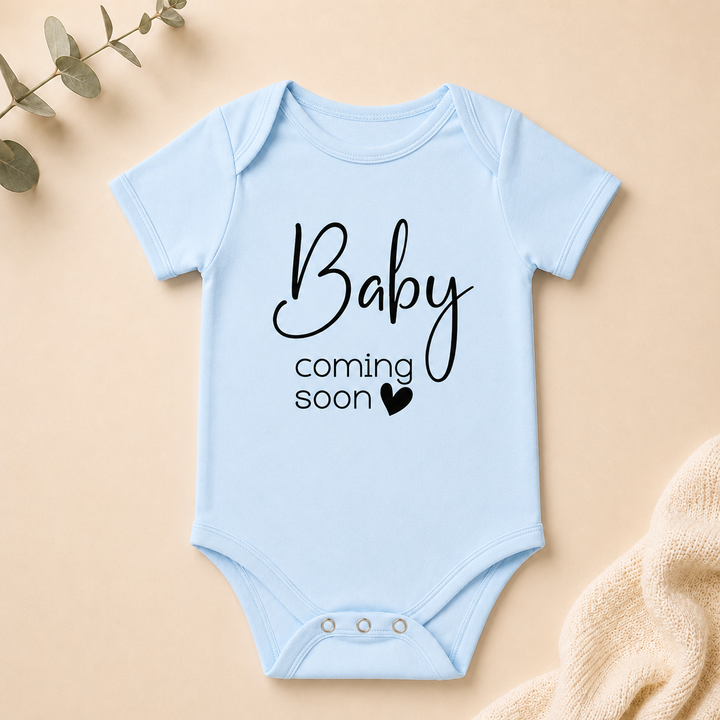 Babyblauw rompertje met tekst “Baby coming soon”, leuk voor zwangerschap aankondigen en fotoshoot
