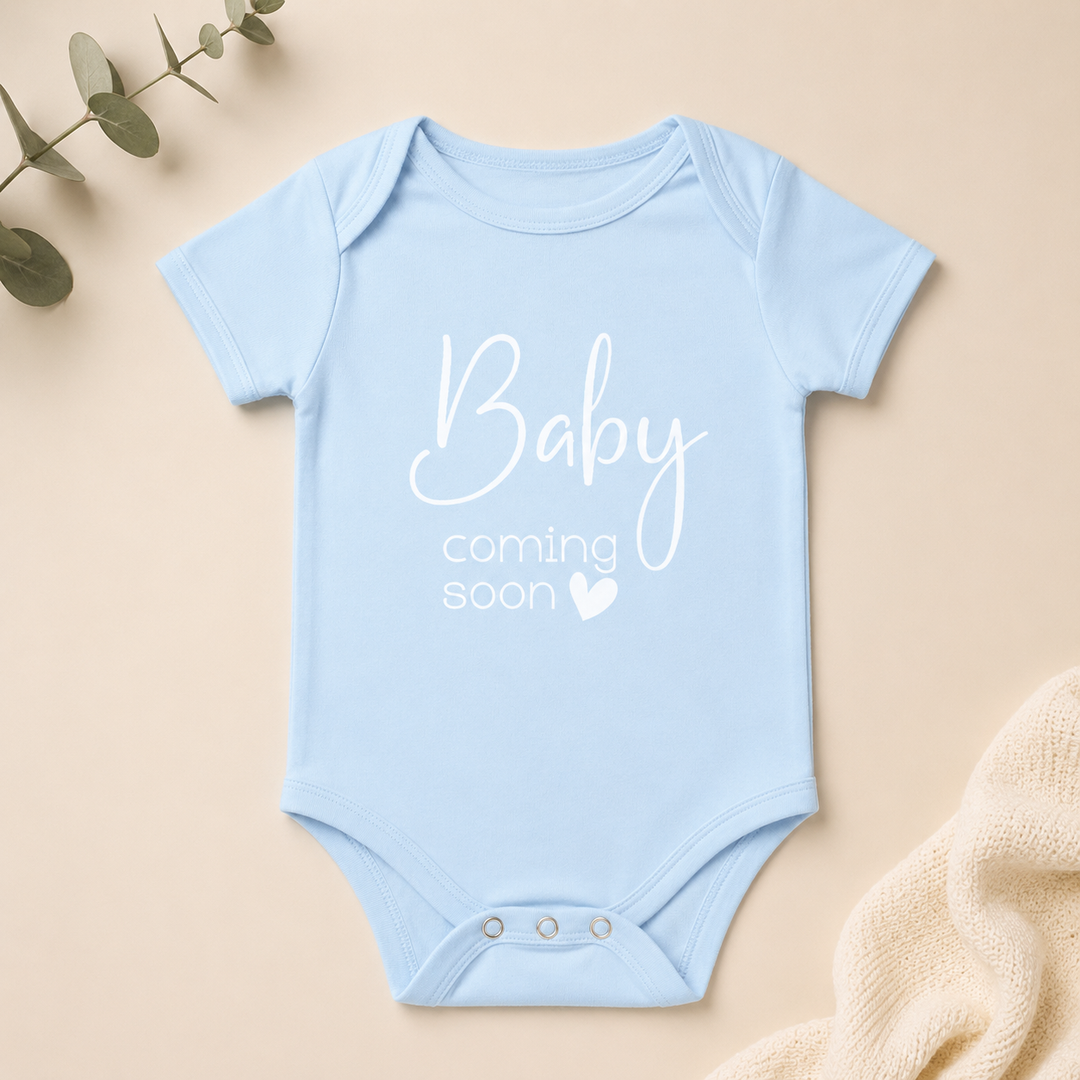 Lichtblauw rompertje met “Baby coming soon”, zachte zwangerschapsaankondiging romper voor social media