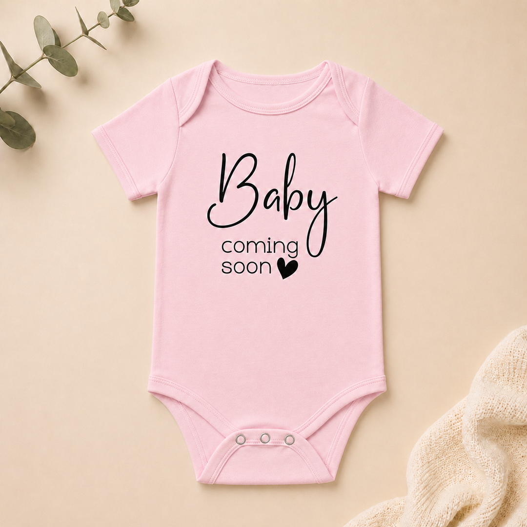 Rompertje met tekst “Baby coming soon” in roze, perfect als originele zwangerschapsaankondiging