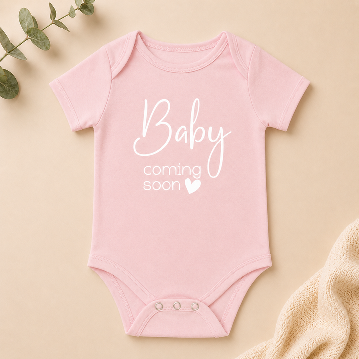Roze rompertje “Baby coming soon” voor een leuke zwangerschapsaankondiging en kraamcadeau