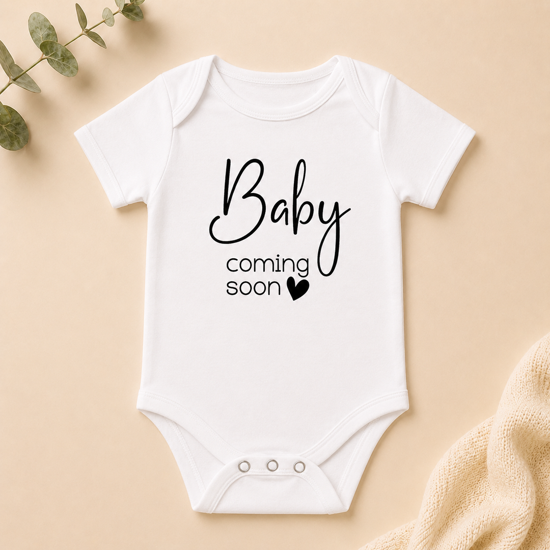 Wit rompertje “Baby coming soon” als originele zwangerschapsaankondiging voor (schoon)ouders