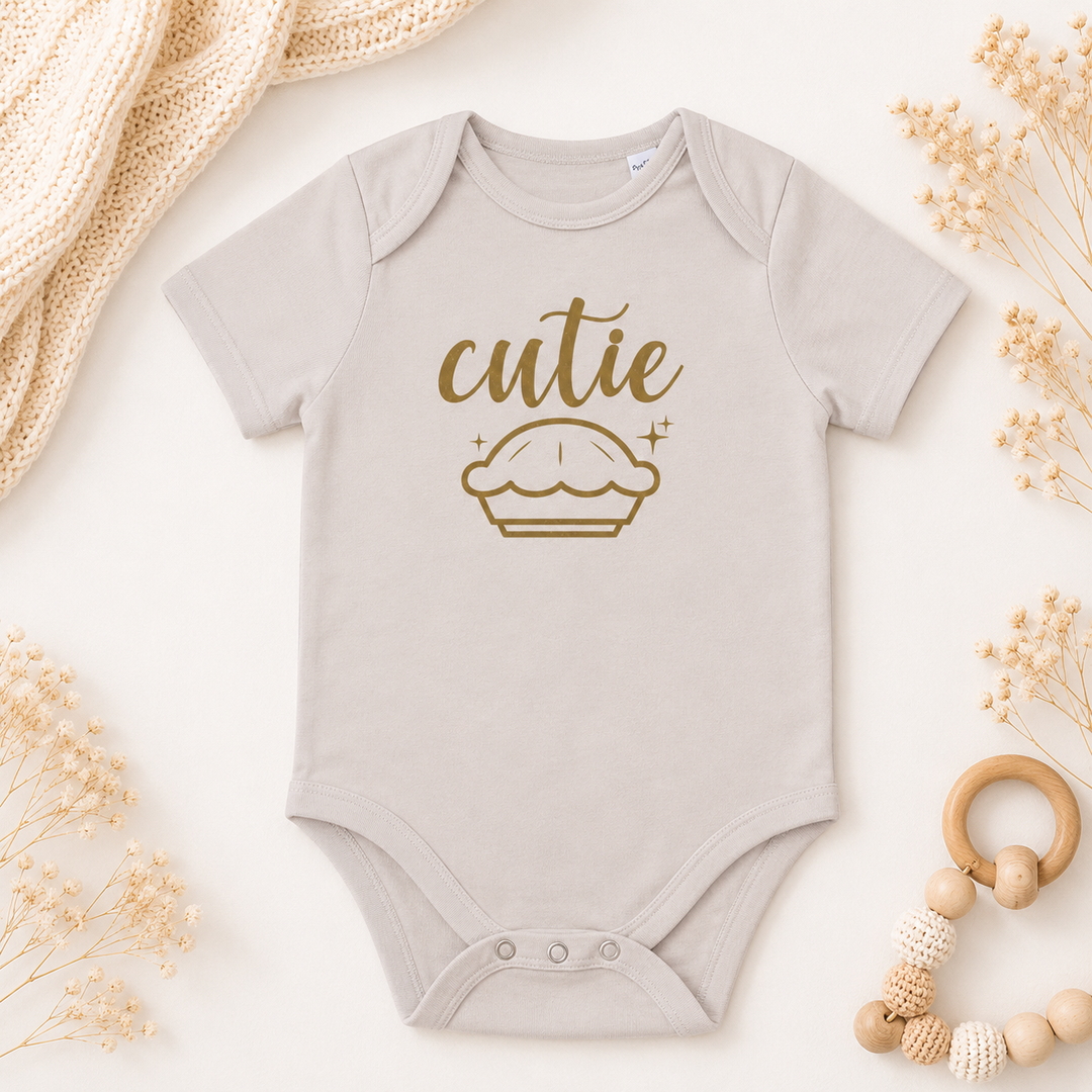 Beige baby rompertje met tekst “cutie pie”, organic katoen, leuk voor zwangerschapsaankondiging of kraamcadeau