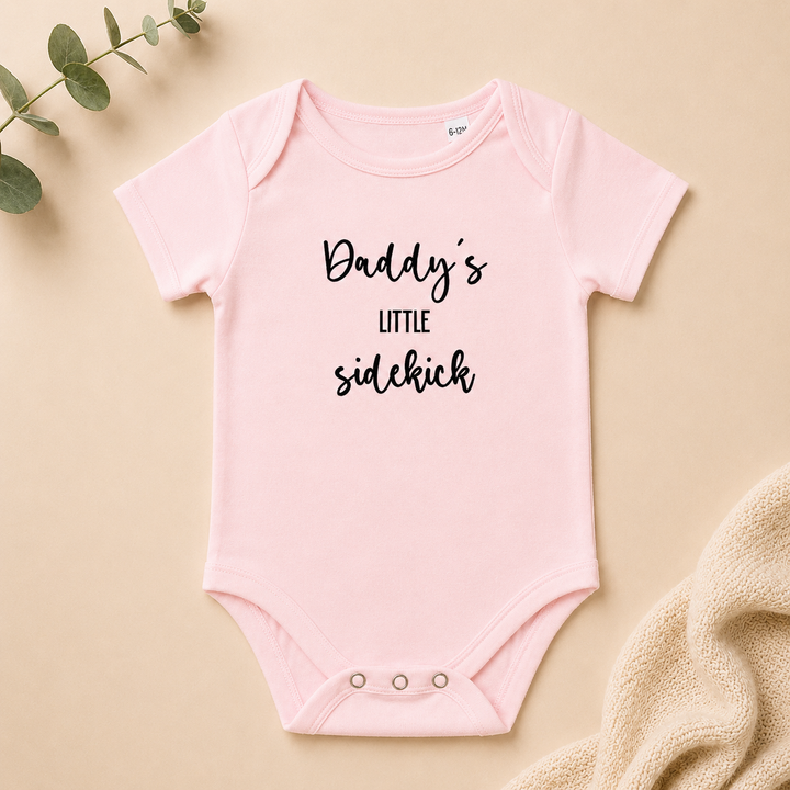 Roze baby rompertje met tekst “Daddy’s little sidekick” leuk als zwangerschapsaankondiging voor (schoon)ouders