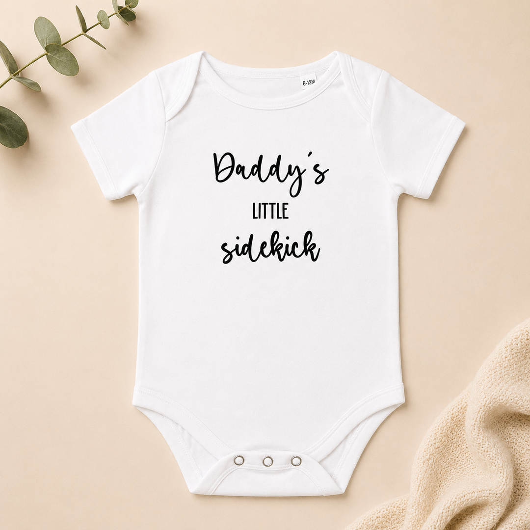 Wit baby rompertje met tekst “Daddy’s little sidekick” voor zwangerschapsaankondiging en babyshower cadeau