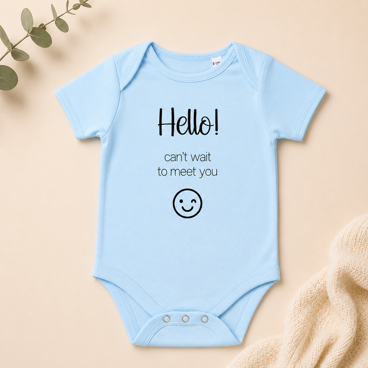 Lichtblauw babyrompertje met tekst “Hello! can’t wait to meet you” voor originele zwangerschapsaankondiging en babyshowercadeau