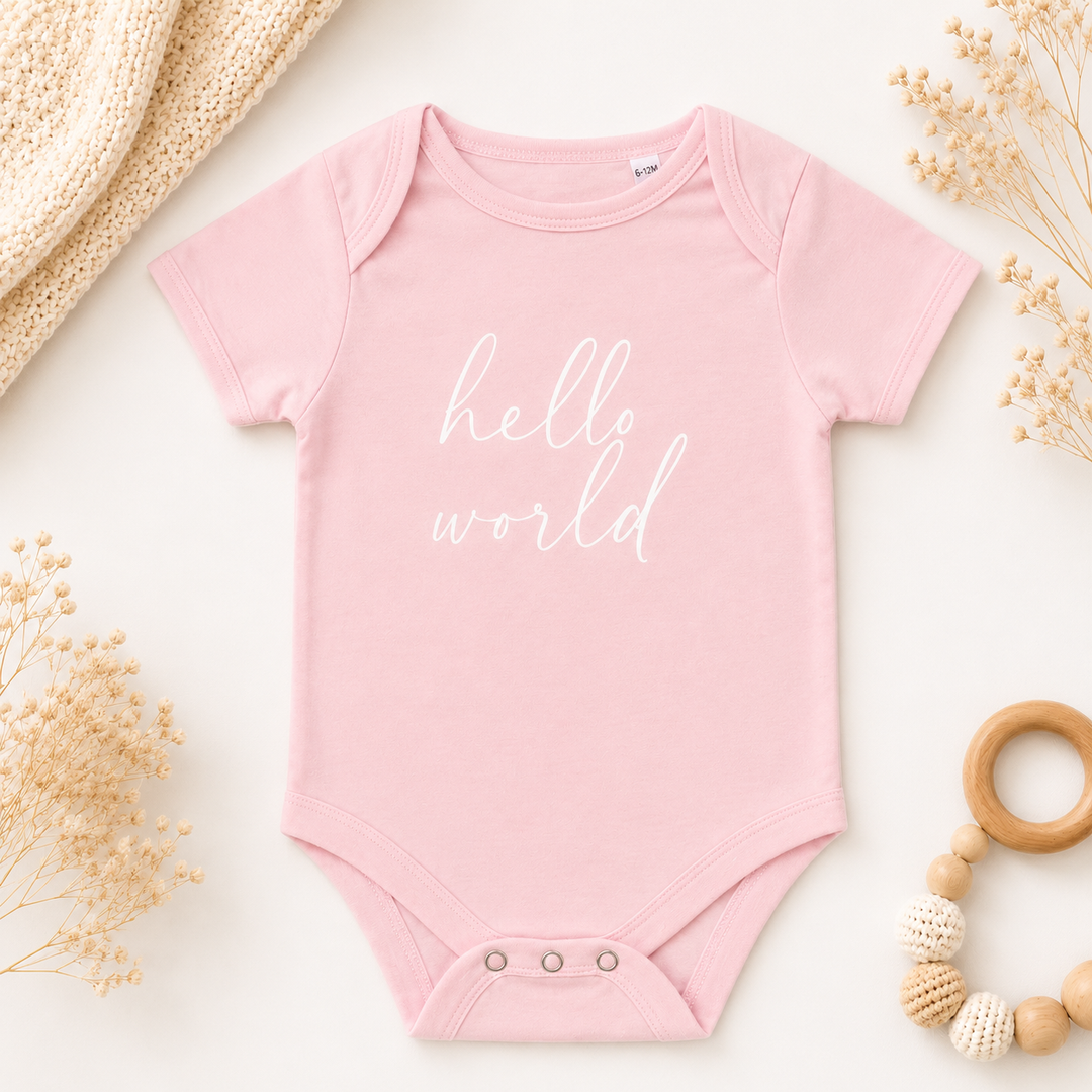Roze rompertje met tekst “Hello World”, leuk rompertje met tekst om zwangerschap aan te kondigen