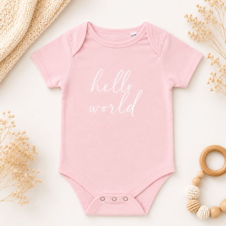 Roze rompertje met tekst “Hello World”, leuk rompertje met tekst om zwangerschap aan te kondigen