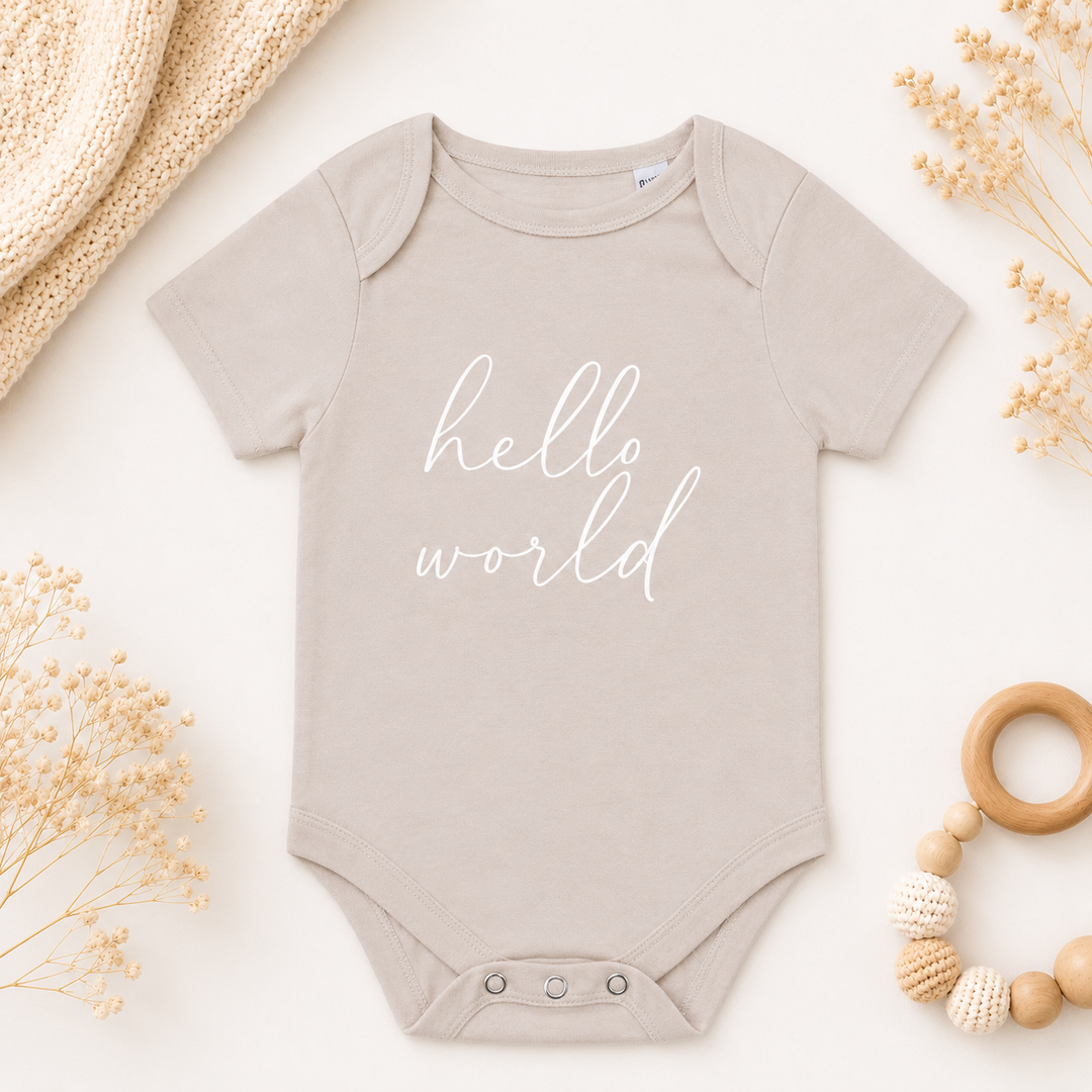 Beige rompertje met tekst “Hello World”, baby romper met tekst voor zwangerschapsaankondiging