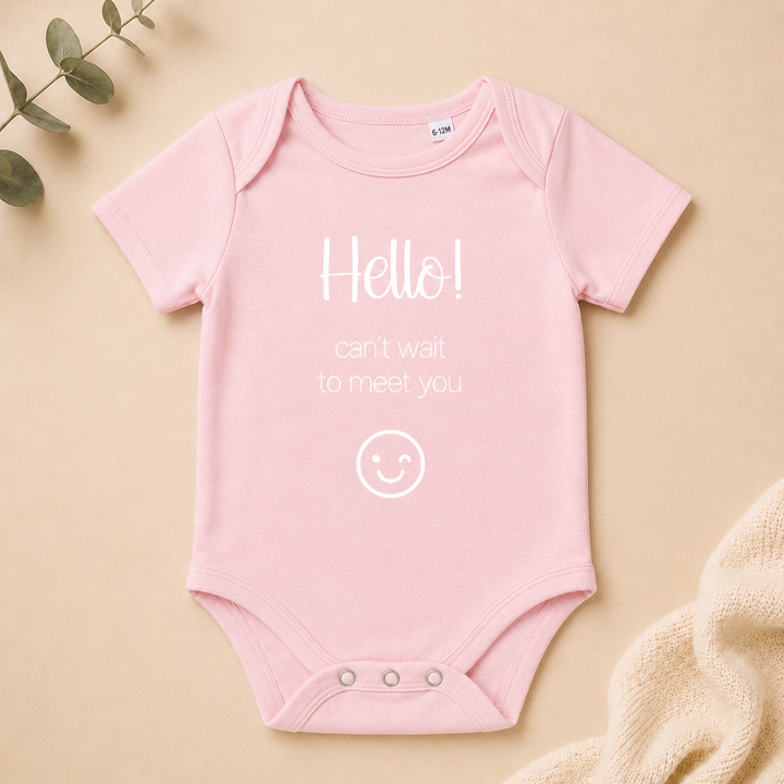 Lichtroze baby rompertje met tekst “Hello! can’t wait to meet you” – leuke zwangerschapsaankondiging