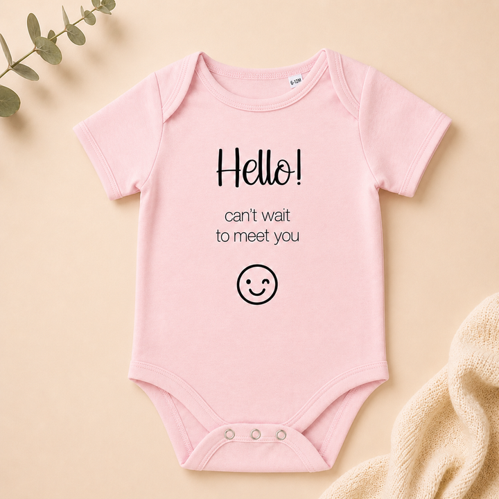 Roze rompertje met tekst “Hello! can’t wait to meet you” – originele zwangerschapsaankondiging romper
