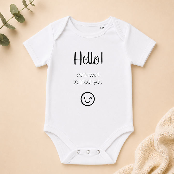 Wit rompertje met tekst “Hello! can’t wait to meet you” – zwangerschapsaankondiging rompertje
