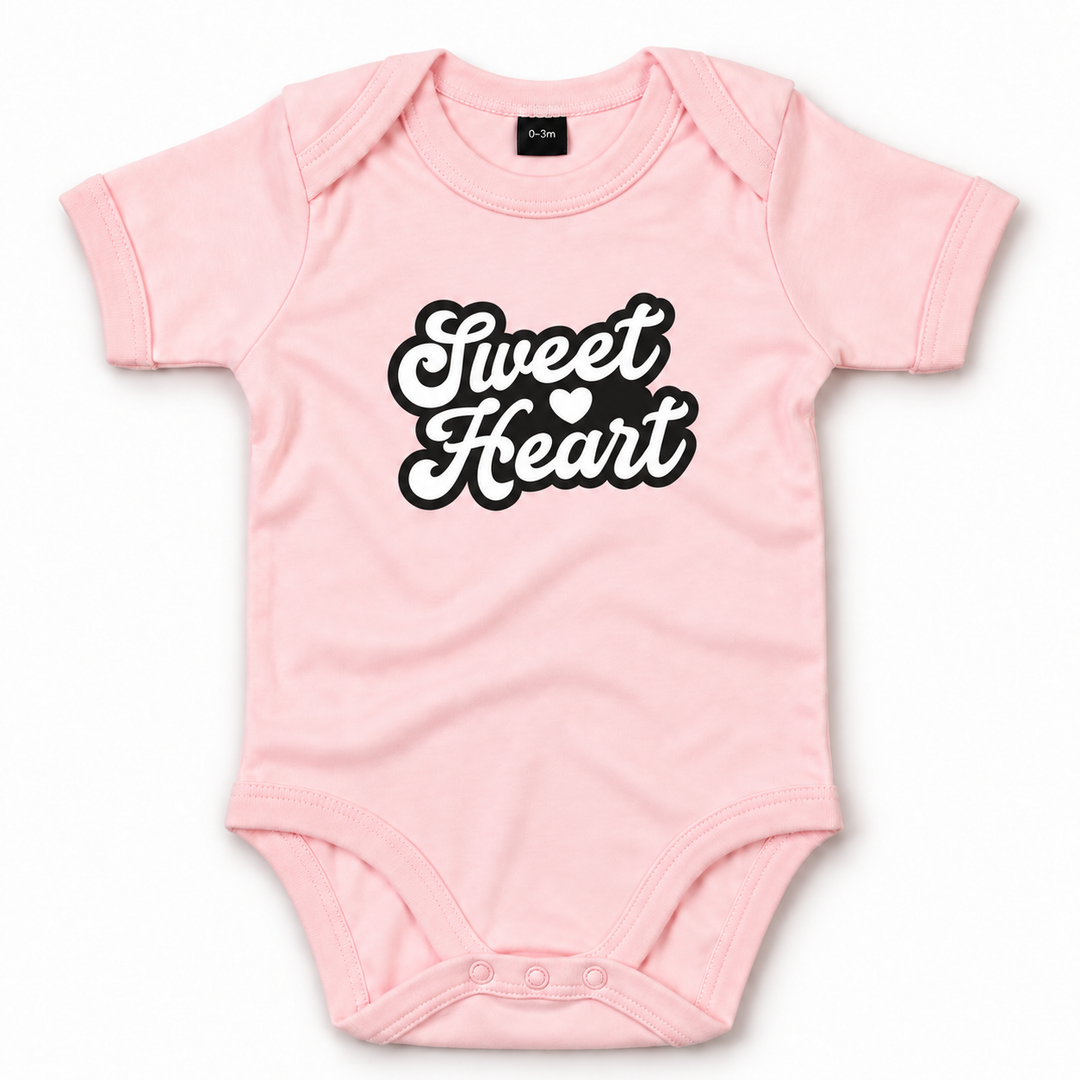 Roze rompertje met zwarte Sweet Heart opdruk en hartje.