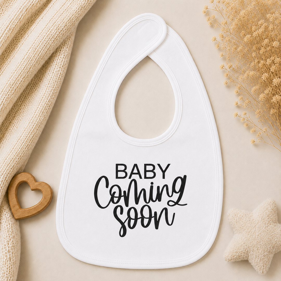 Wit slabbetje met opdruk “Baby coming soon”, leuk voor zwangerschap aankondigen aan opa en oma