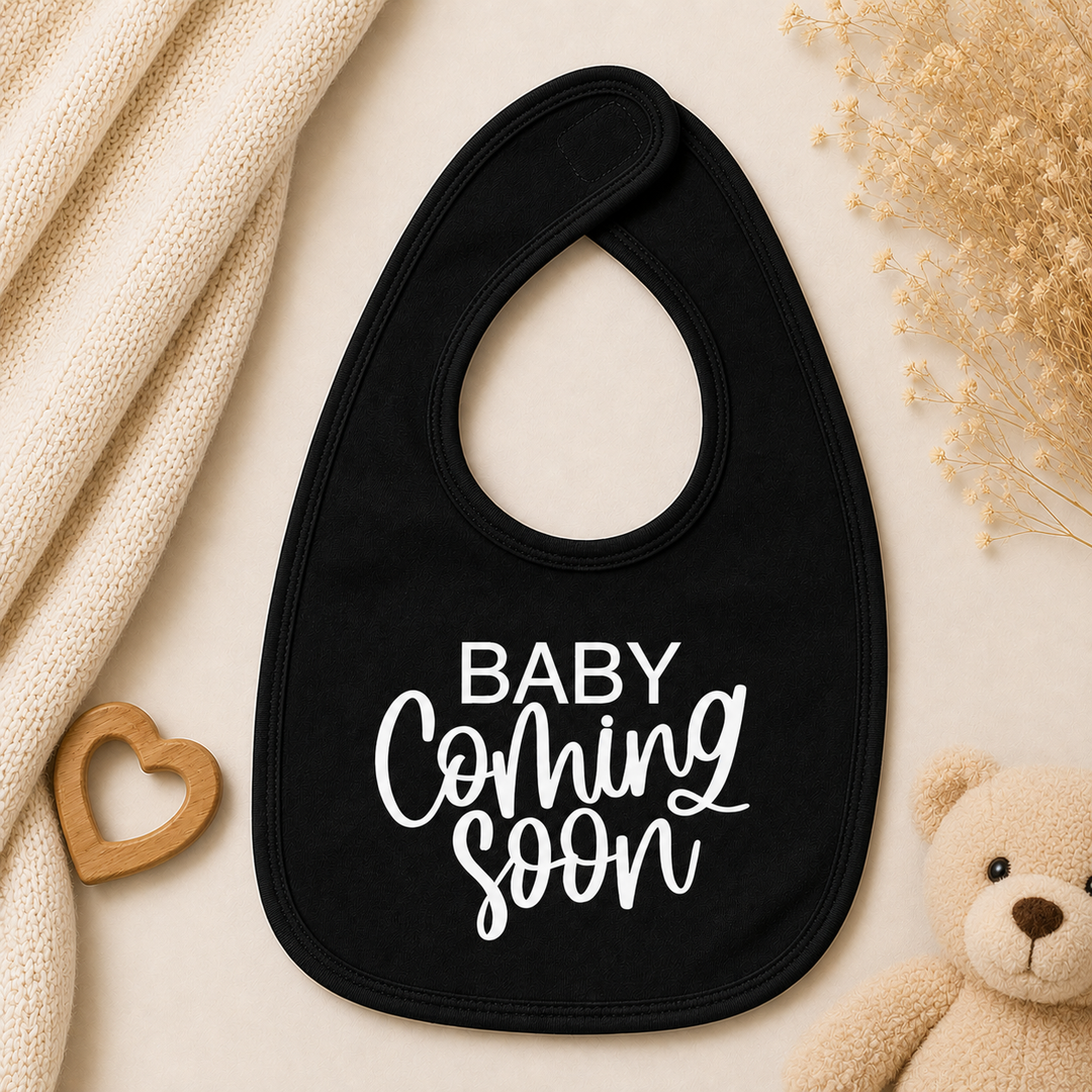 Zwart baby slabbetje met tekst “Baby coming soon”, origineel cadeau voor zwangerschapsaankondiging