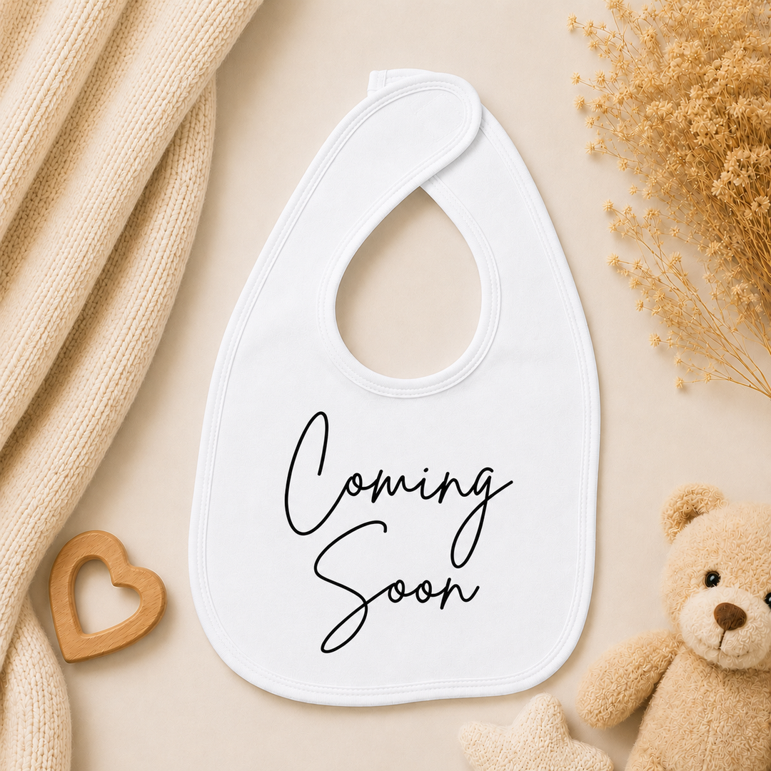 Wit slabbetje met “Coming soon” tekst, ideaal voor zwangerschap aankondigen aan opa en oma
