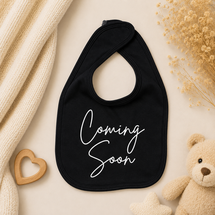 Zwart baby slabbetje met tekst “Coming soon”, origineel cadeautje voor zwangerschapsaankondiging