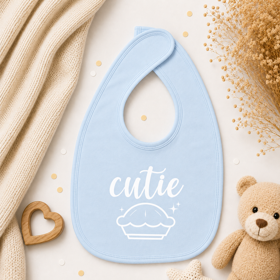 Babyblauw slabbetje met tekst “cutie pie”, dubbellaags organic katoen met klittenbandsluiting, ideaal als kraamcadeau