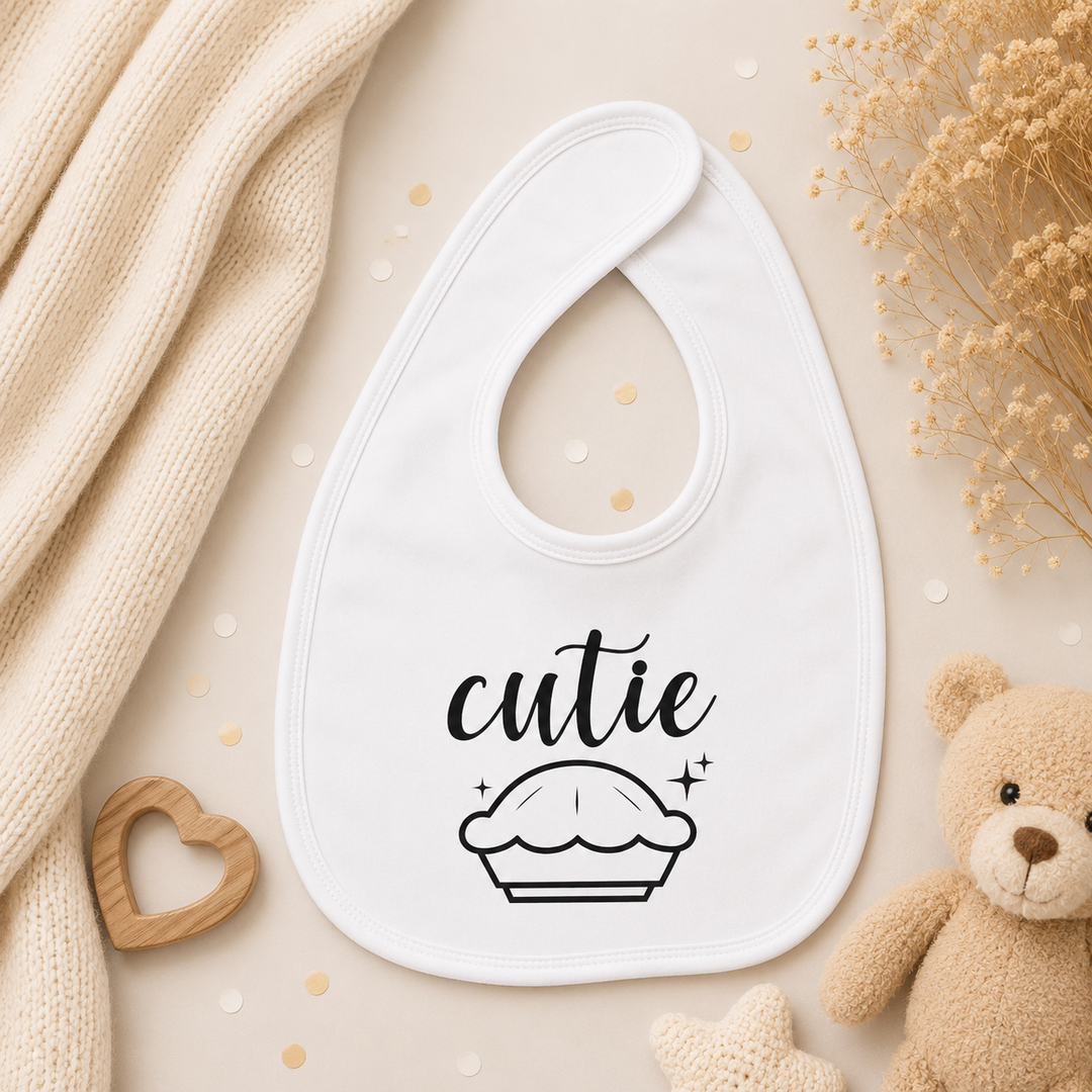 Wit baby slabbetje met tekst “cutie pie”, dubbellaags en zacht, geschikt als originele zwangerschapsaankondiging