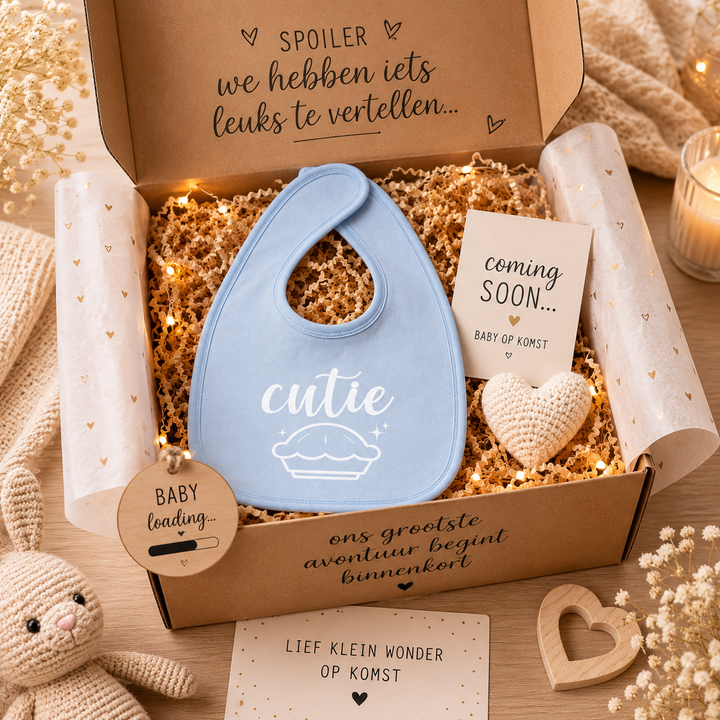 Blauw slabbetje met tekst “cutie pie” in zwangerschap aankondiging cadeaupakket met kaartje “coming soon”, hartje en baby loading tag – origineel cadeaumoment.