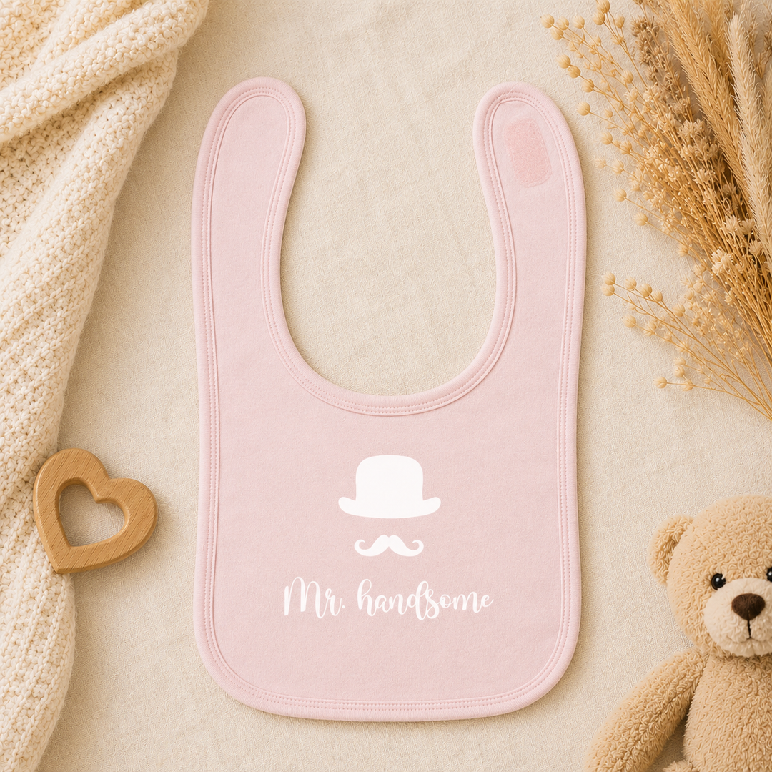 Roze baby slabbetje met tekst “Mr. handsome”, dubbellaags slab met klittenband (0–18 maanden)
