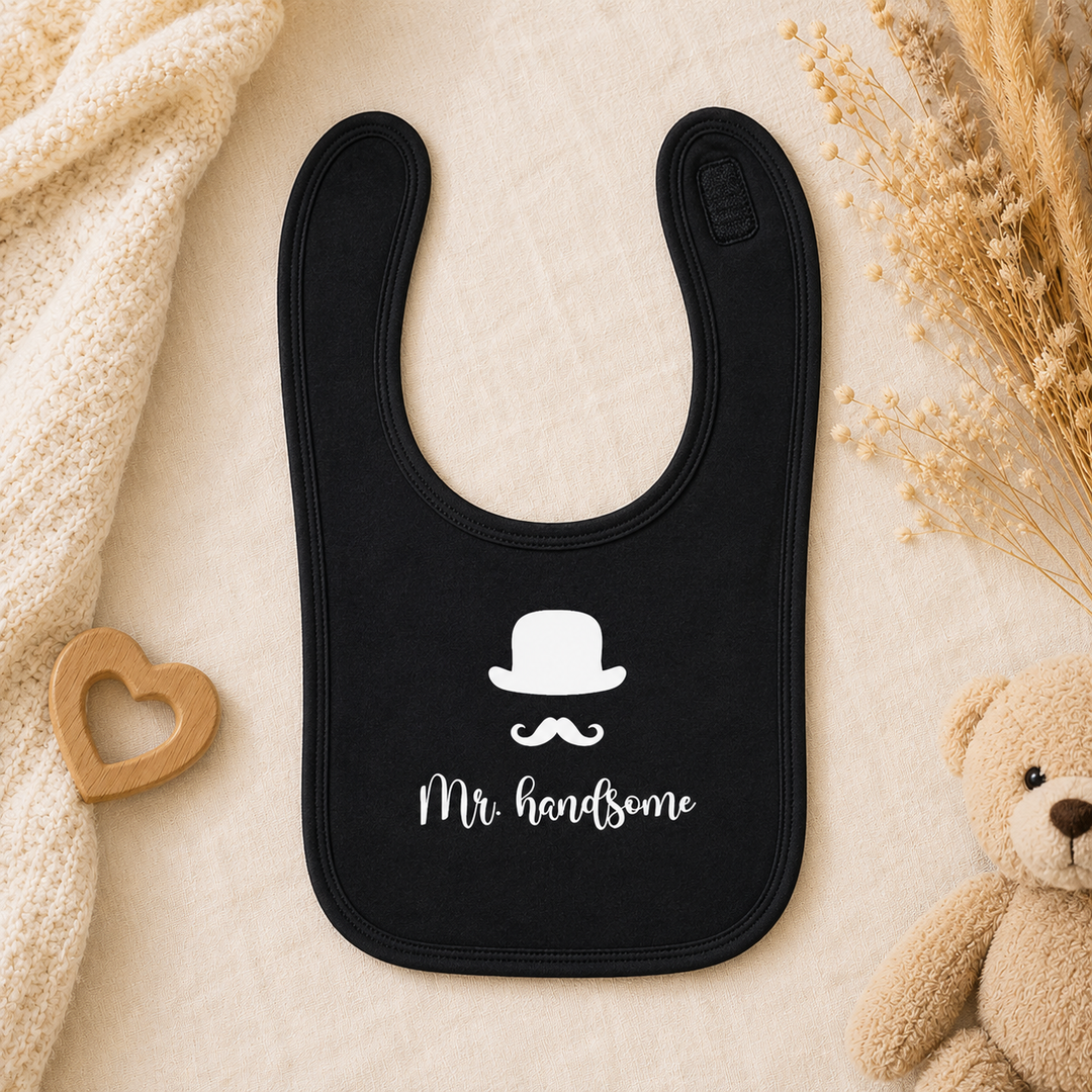 Zwart baby slabbetje met tekst “Mr. handsome”, dubbellaags organic katoen met klittenbandsluiting