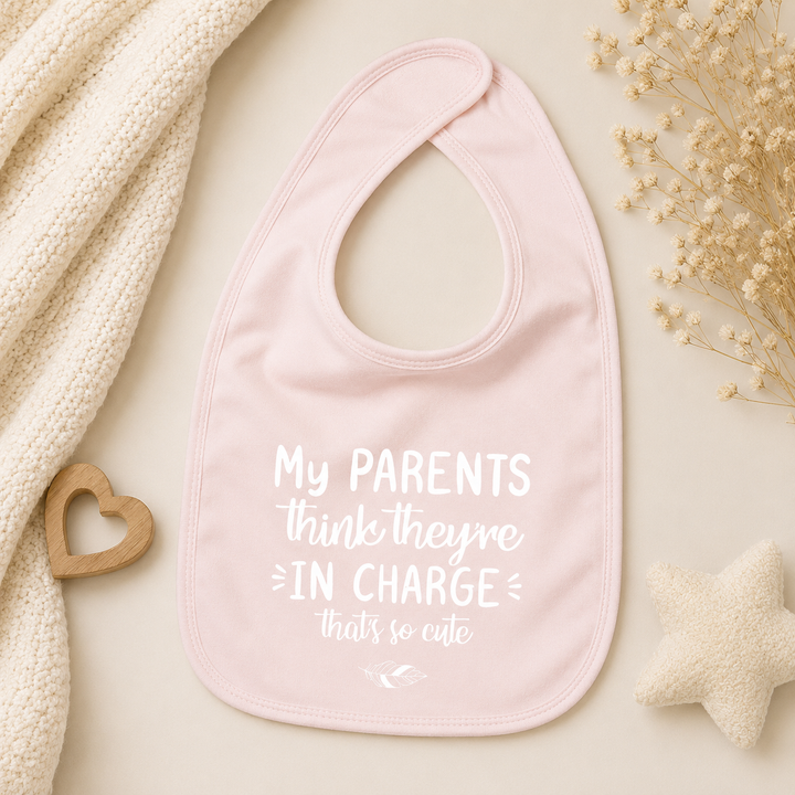 Baby roze slabbetje met tekst “My parents think they’re in charge, that’s so cute” – leuk slabbetje met grappige tekst