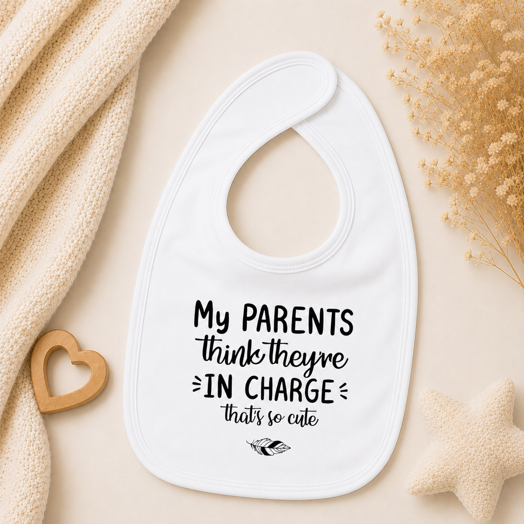 Wit baby slabbetje met tekst “My parents think they’re in charge, that’s so cute” – slab met tekst voor baby